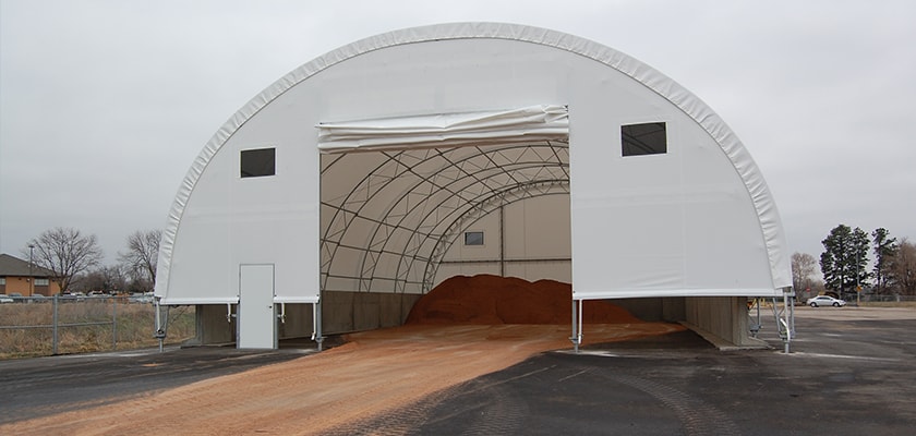 Photo of a fabric covered building with roll up flap on front.